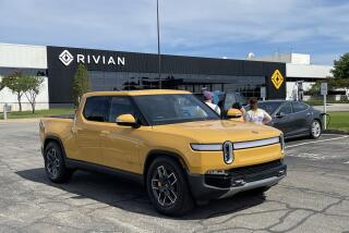 A family from Kentucky picks up a yellow Rivian truck at the Rivian factory in Normal, Illinois.