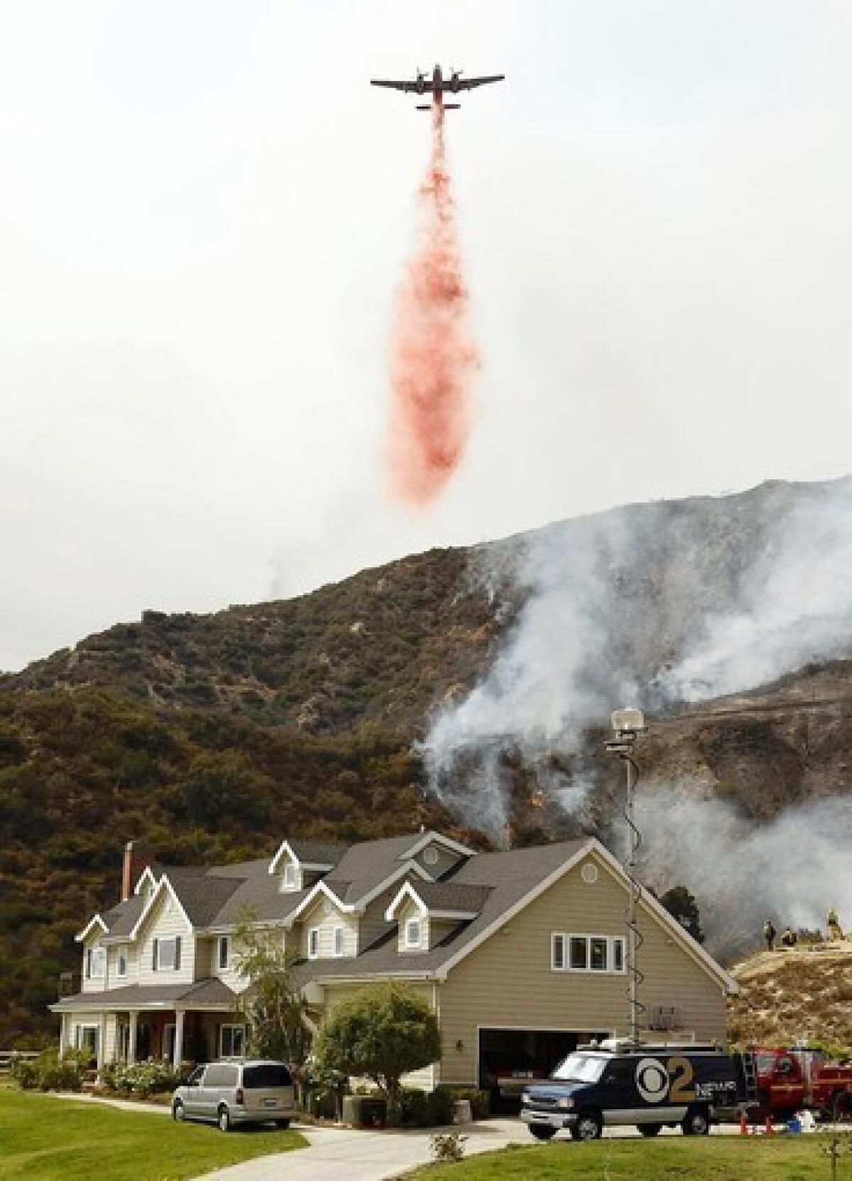 An airplane drops fire retardant on flames in the hills above La Cañada Flintridge in 2009. Slightly more than half of the homes at high risk from wildfire are in Southern California, a study found.