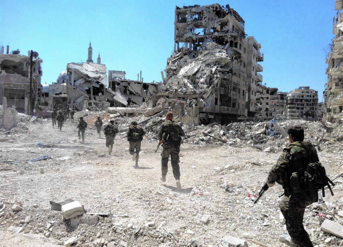 A photo from July 2013 shows Syrian government forces patrolling in the central city of Homs. Essential to the government’s resurgence has been its well-armed military. Long trained for a traditional land war with Israel, it has become increasingly adept at fighting an insurgency.