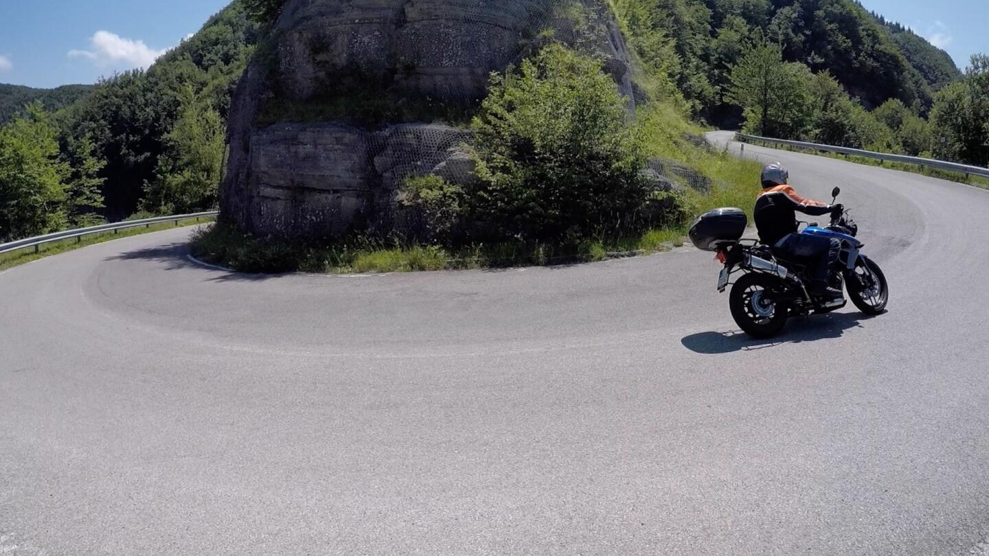 A motorcyclist loops around a hairpin turn in the Sambuca Pass northeast of Florence, Italy.