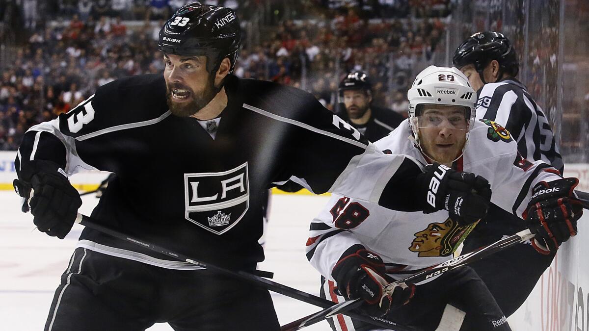 Kings defenseman Willie Mitchell, left, battles with Chicago Blackhawks forward Ben Smith during Game 3 of the Western Conference finals Saturday. Mitchell's play has helped the Kings keep Chicago's offense in check.