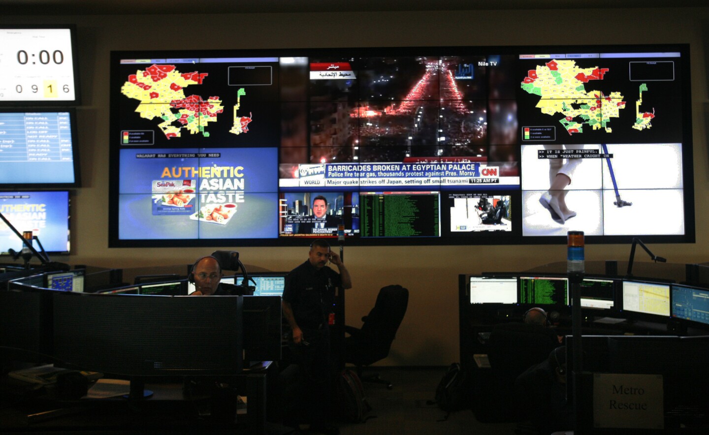 The Los Angeles Fire Department dispatch center with electronic maps of the city as well as television station broadcasts on the wall behind the dispatchers on December 07, 2012. In the event of a major occurrence, the dispatchers can watch TV helicopter coverage to help broaden their understanding of the situation.