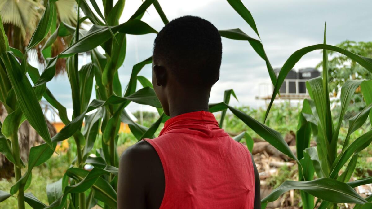 Eliza, 17, stands next to crops in a courtyard in the town of Rumbek, South Sudan, on July 30.