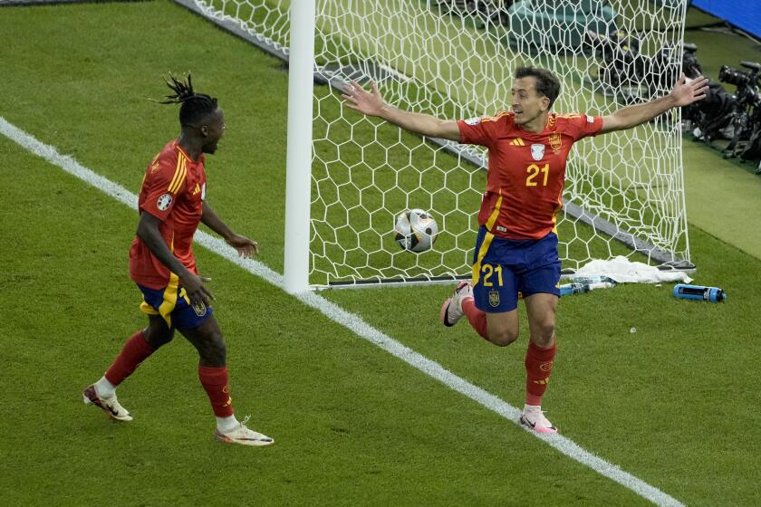 Spain's Mikel Oyarzabal, right, celebrates after scoring his side's 2nd goal against England during the final match at the Euro 2024 soccer tournament in Berlin, Germany, Sunday, July 14, 2024. (AP Photo/Thanassis Stavrakis)