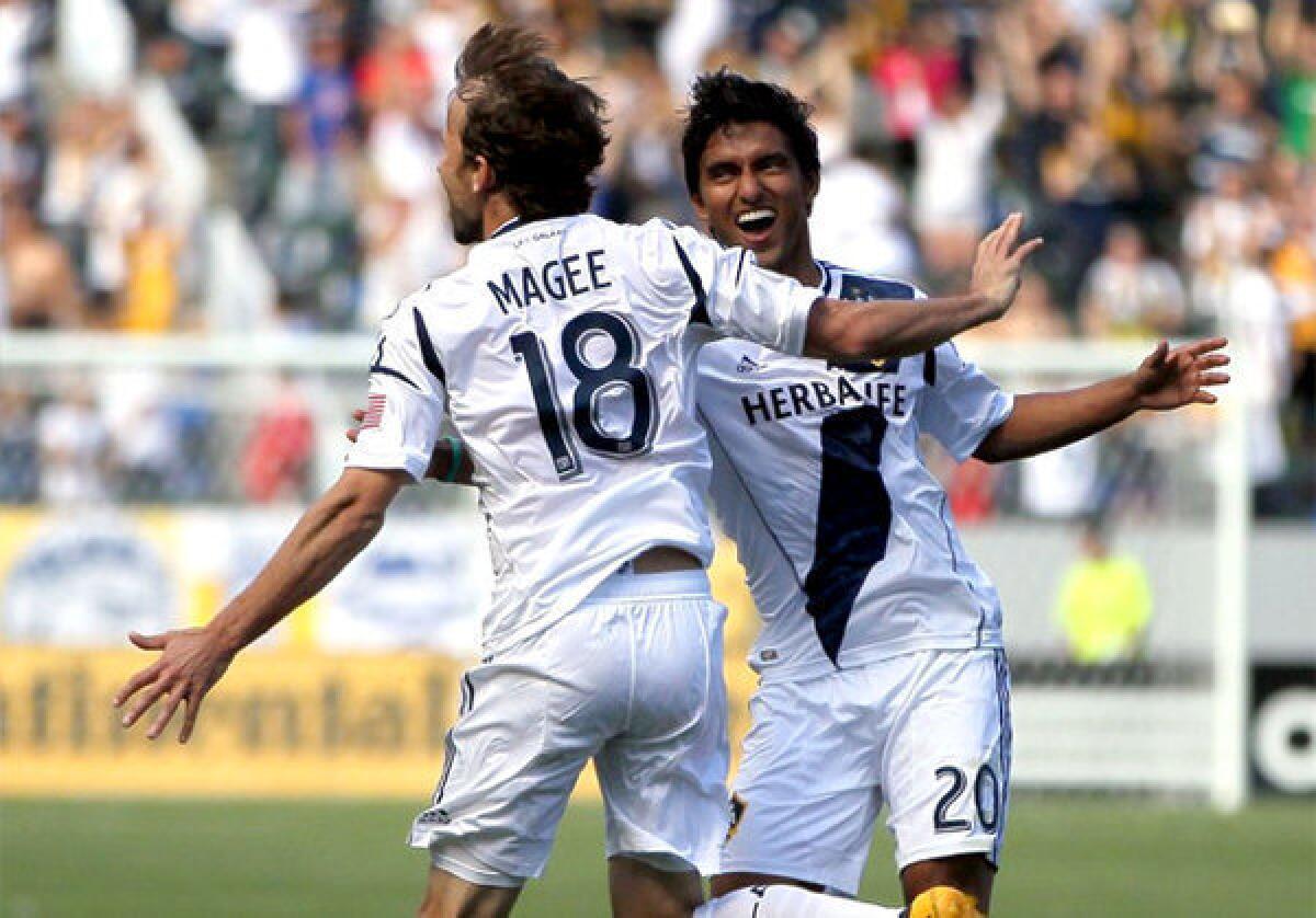 Galaxy's Mike Magee celebrates one of his three goals with teammate A.J. DeLaGarza.