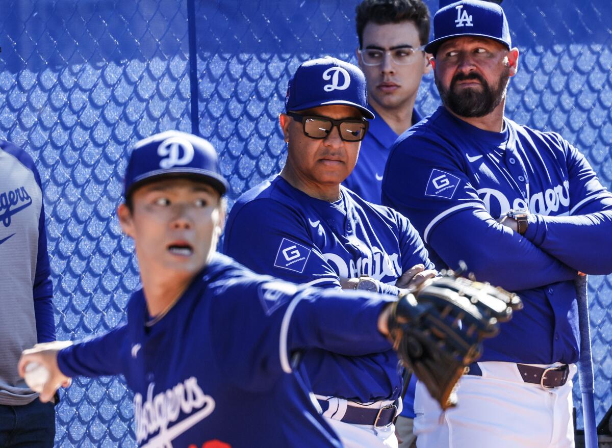Dodgers manager Dave Roberts looks on as pitcher Yoshinobu Yamamoto works out at Camelback Ranch on Feb. 14.