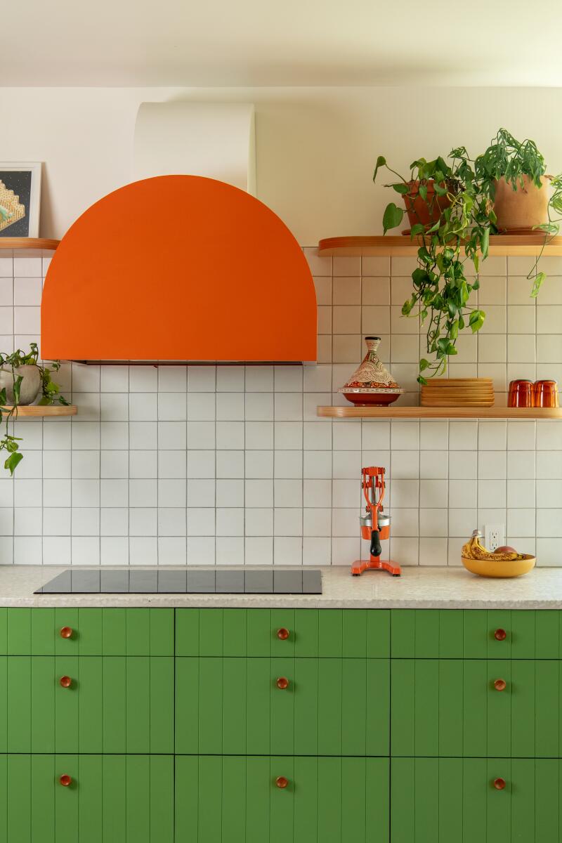 Bright green kitchen cabinets and an orange metal hood
