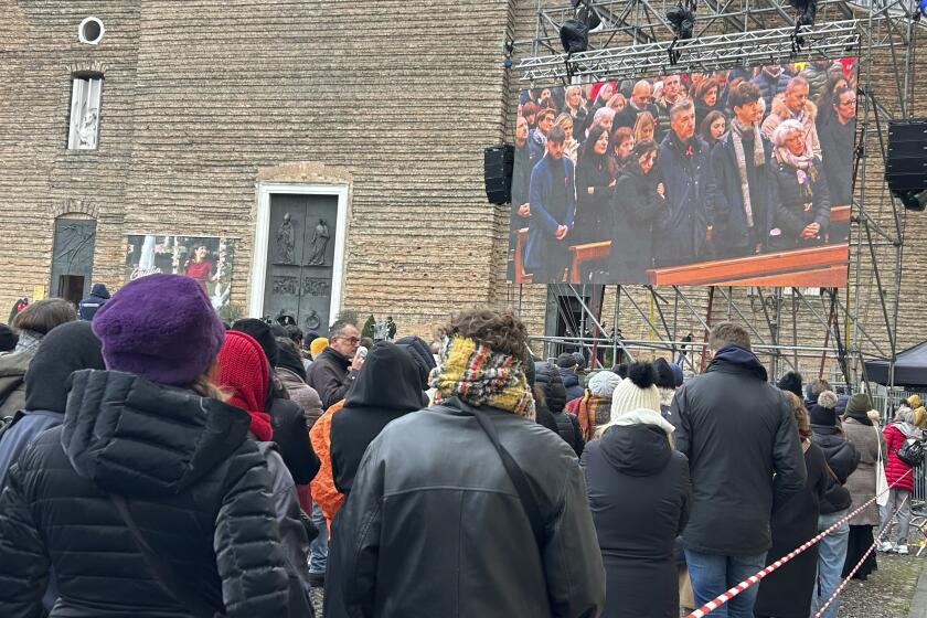 Gente observa en una pantalla el funeral de Giulia Cecchettin, frente a la iglesia de Santa Giustina en Padua, Italia, martes 5 de diciembre de 2023. (Lucrezia Granzetti/LaPresse via AP)