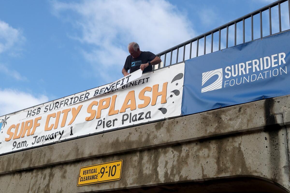 KC Fockler, Surfrider Huntington/Seal Beach chapter co-chair, fixes a Surf City Splash banner on Wednesday. 