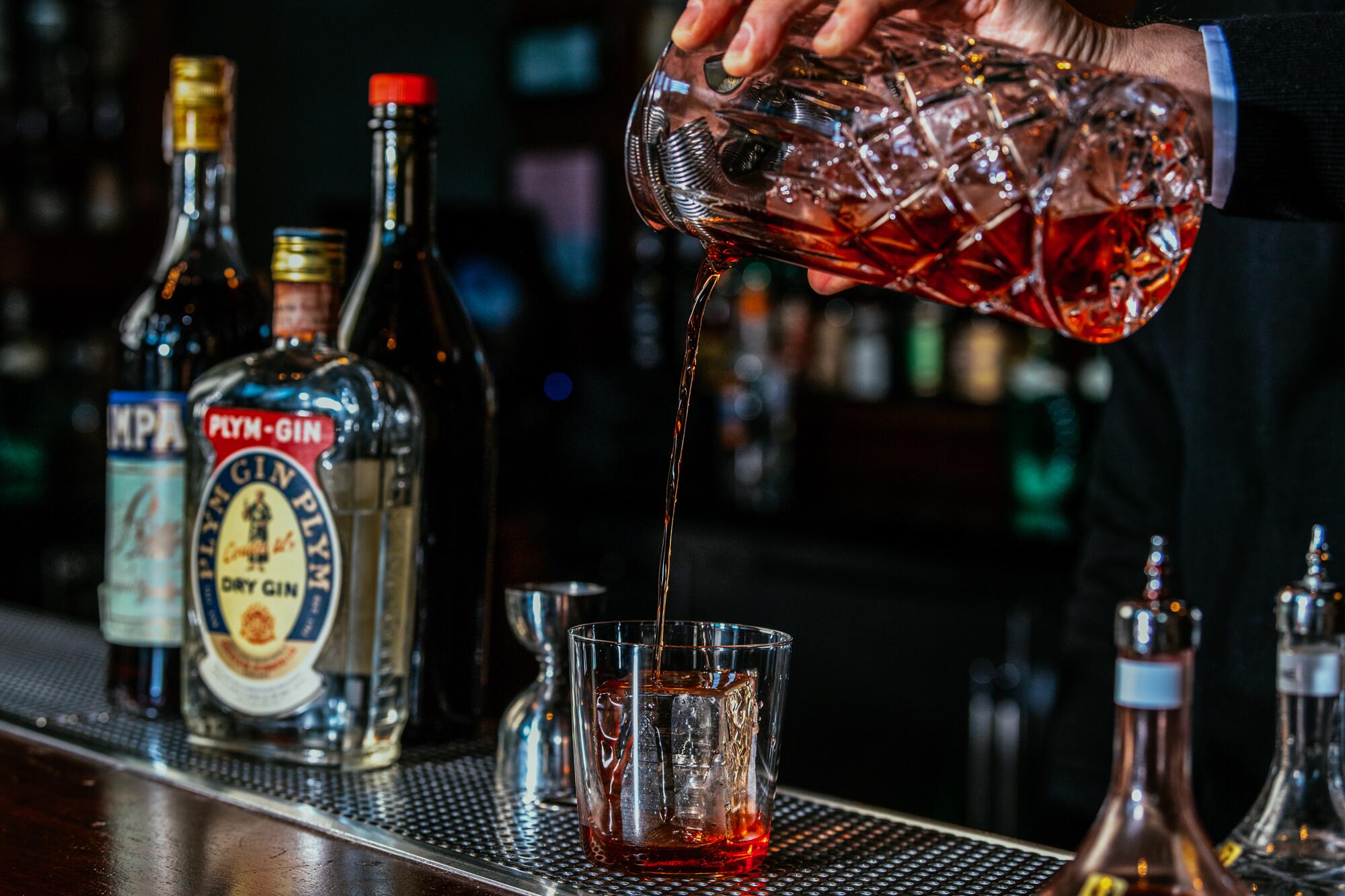 A bartender makes a Negroni.