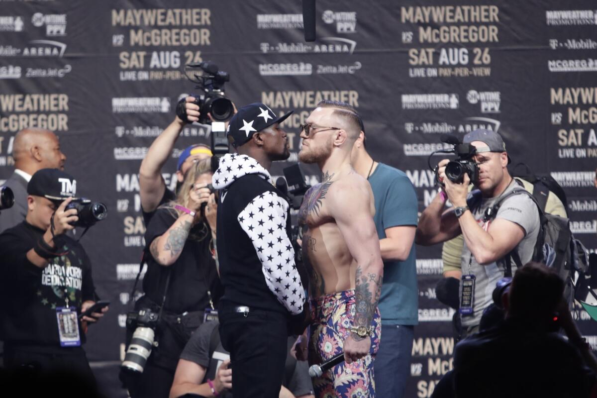 Floyd Mayweather Jr., left, and Conor McGregor, of Ireland, pause for photos during a news conference at Barclays Center Thursday, July 13, 2017, in New York. (AP Photo/Frank Franklin II)