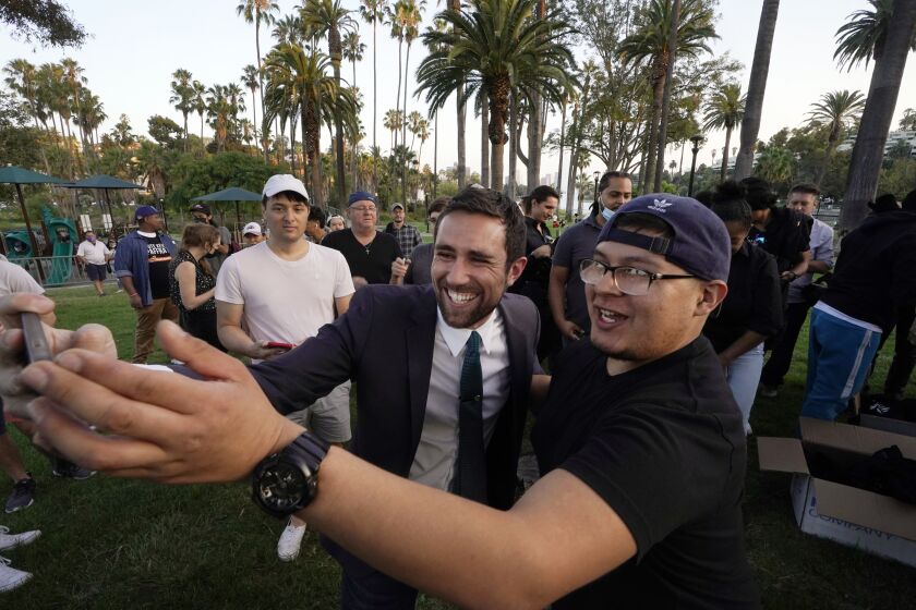 In this Friday, Aug, 20, 2021, Kevin Paffrath, center, a real estate agent and YouTube content creator, center, takes a selfie with follower, at a campaign rally at Echo Park Lake in Los Angeles. Paffrath, 29, is one of the Democrats running in the recall against California Gov. Gavin Newsom. (AP Photo/Damian Dovarganes)