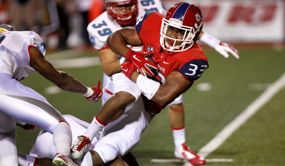 Fresno State running back Marteze Waller works for extra yards and a first down after contact against New Mexico on Friday night.