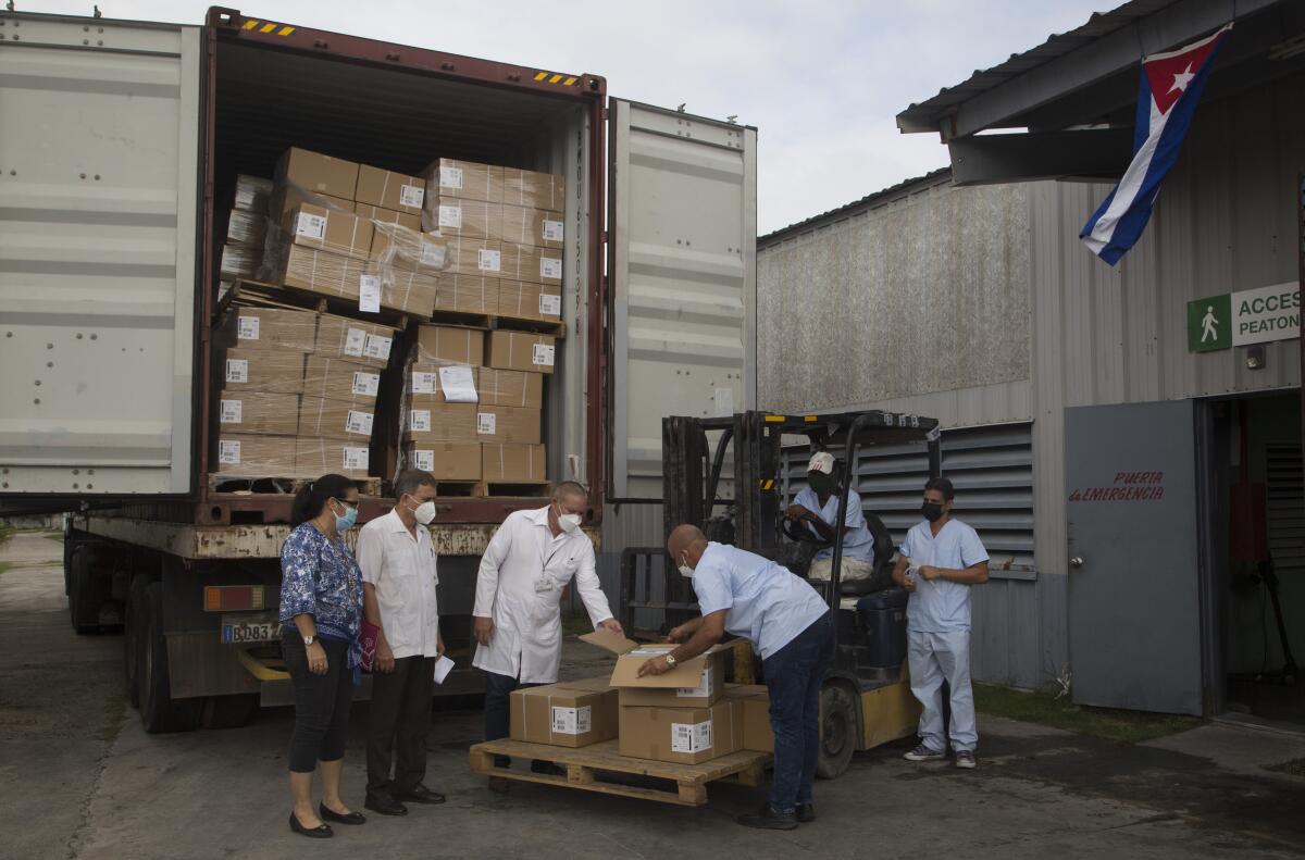 Trabajadores estatales reciben una donación de jeringas durante la pandemia en La Habana, Cuba