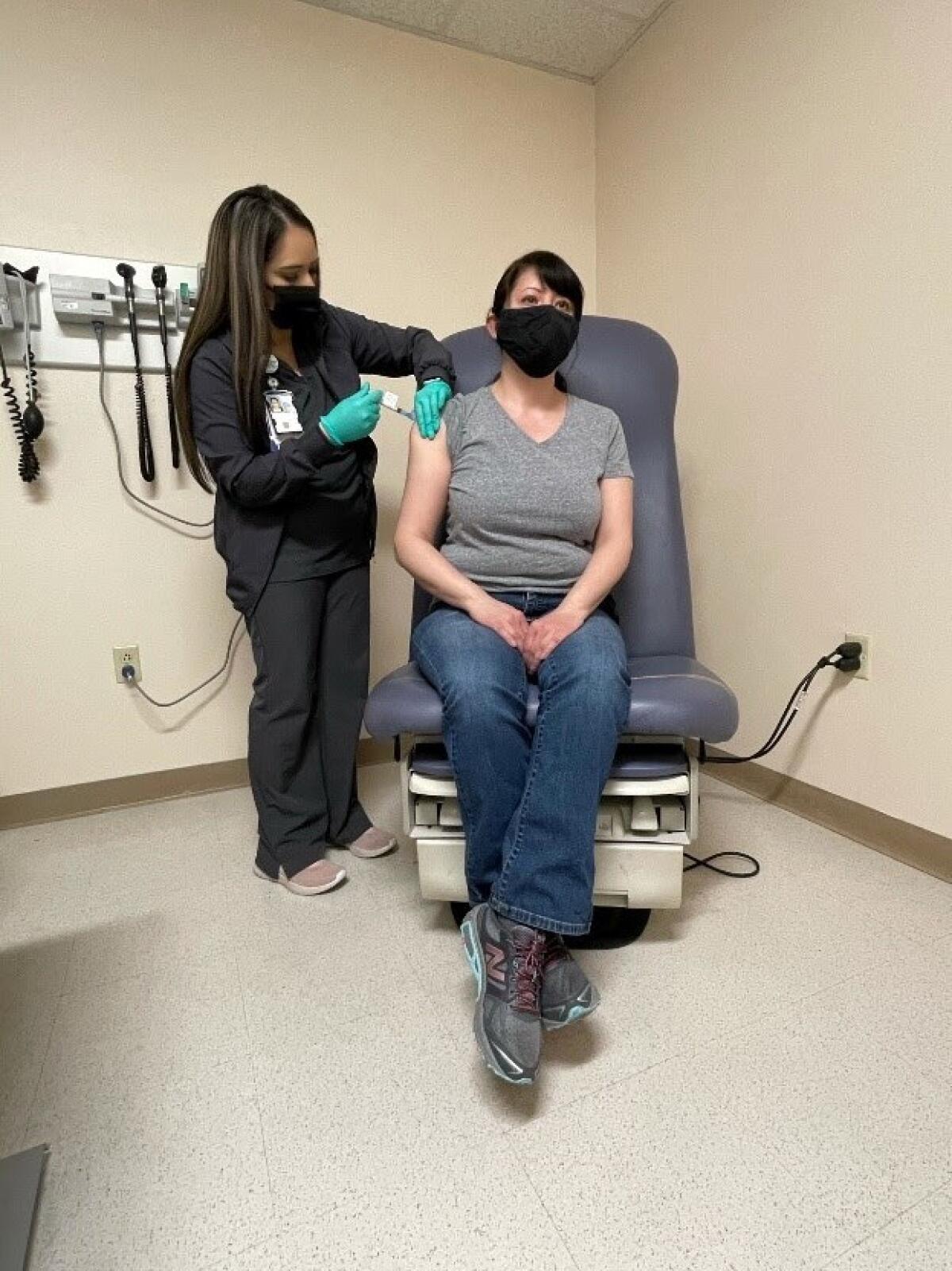 A healthcare worker administers a vaccine.