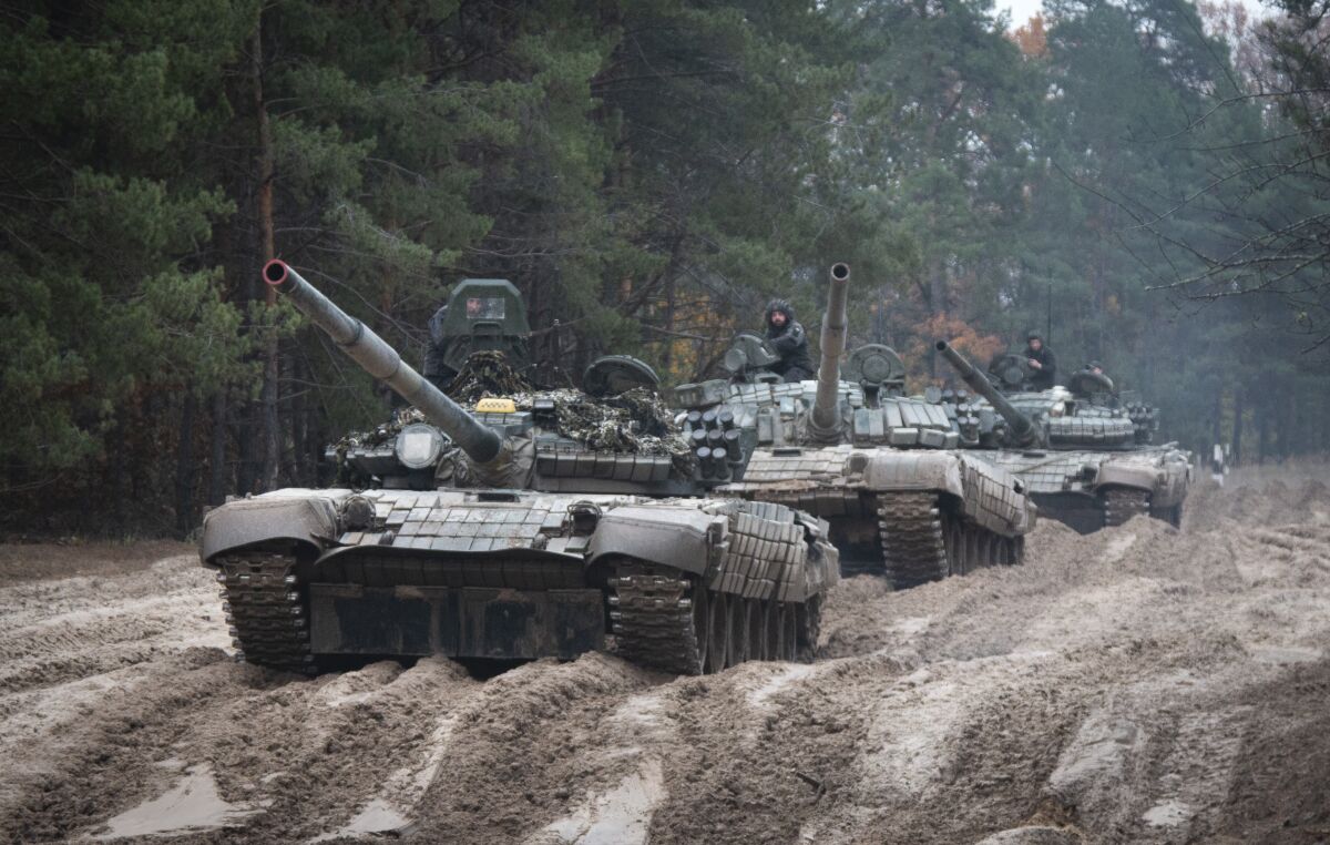 Ukrainian soldiers on captured Russian tanks