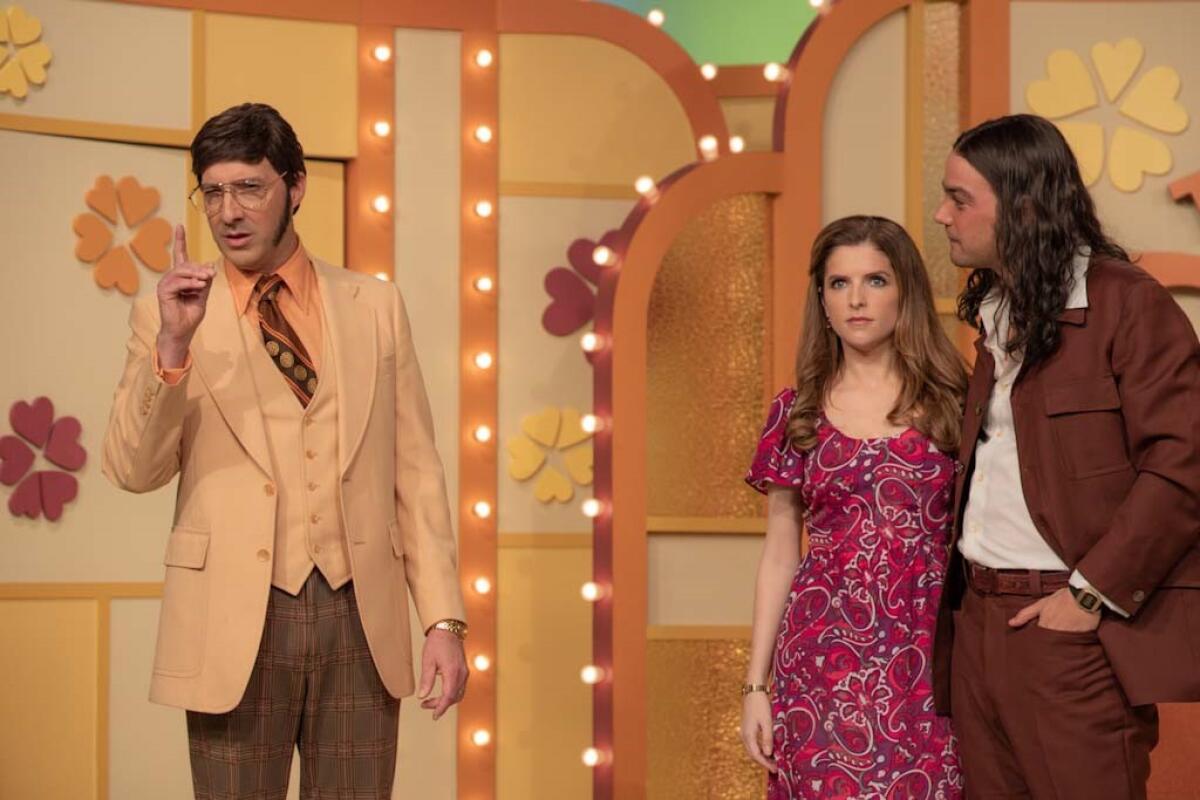 The host and a couple on a 1970s dating game show.