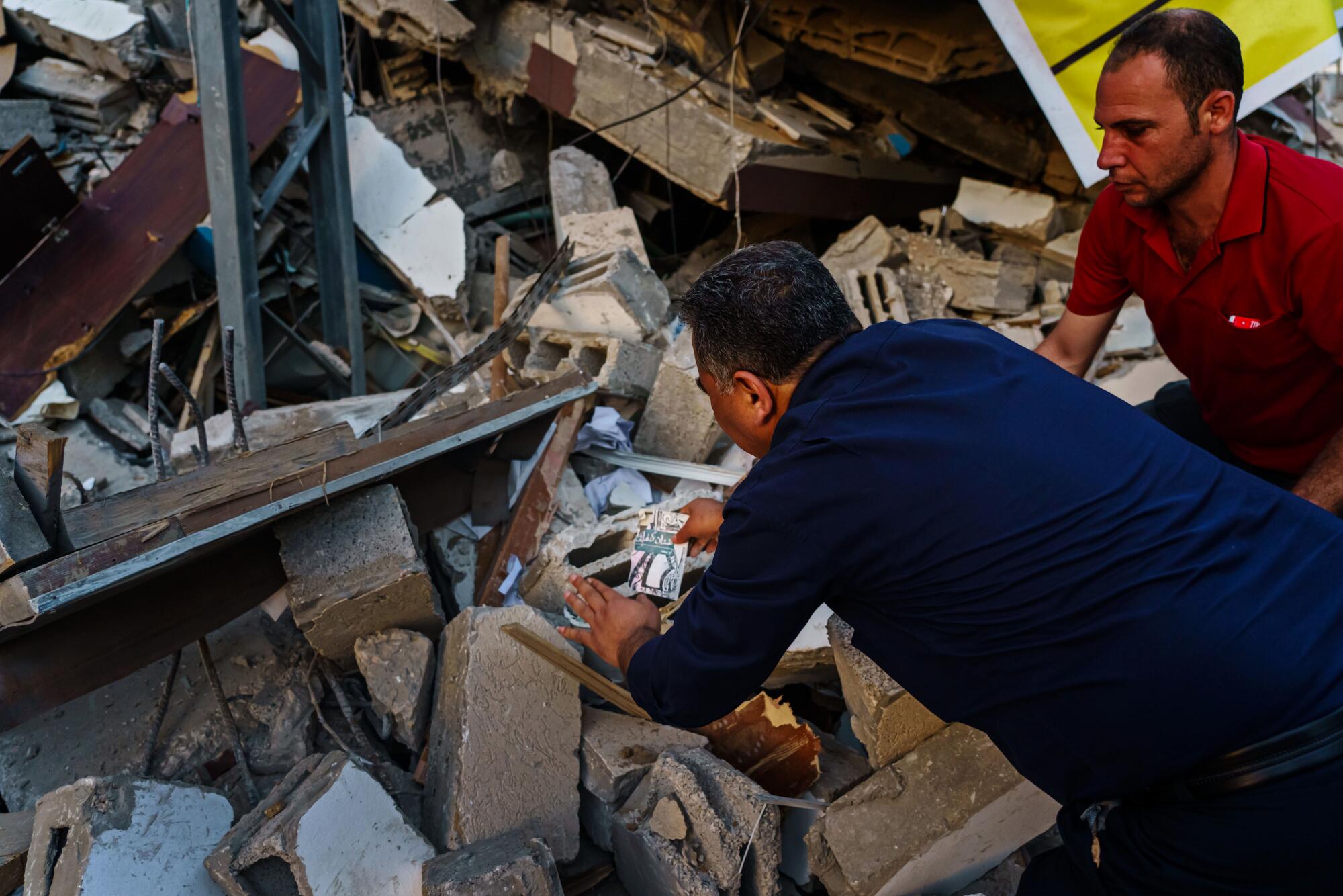 Samir Mansour gathers books from rubble