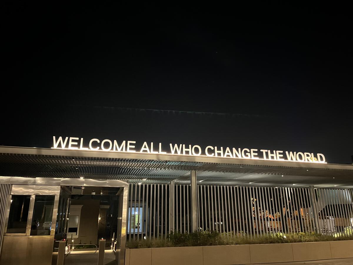A sign above an entrance to the Universal Studios lot reads, "Welcome All Who Change the World."