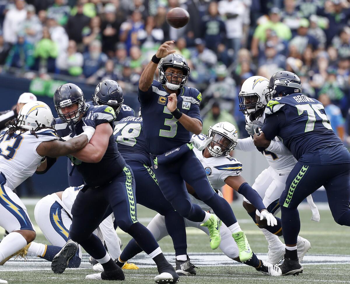 Seattle Seahawks quarterbck Russell Wilson feels pressure from the Chargers' defensive line in the second quarter Sunday at Century Link Field in Seattle.