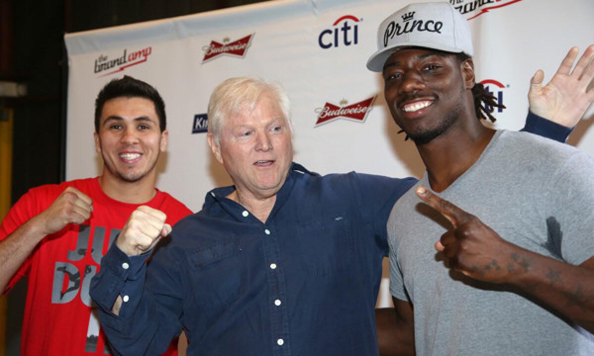 Michael King, center, president of King Sports, poses with heavyweight boxers Alex Flores, left, and Charles Martin during a weigh-in Tuesday in Santa Monica. King is determined to return boxing to its former glory, and the wealthy television executive has spent millions in his pursuit over the last few years.