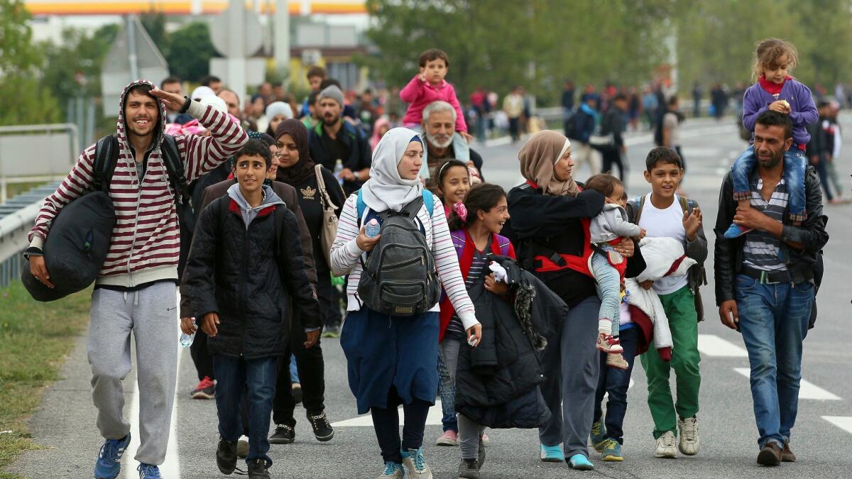 This 2015 file photo shows migrants walking on a highway toward Vienna after crossing the Hungarian-Austrian border near Nickelsdorf, Austria.