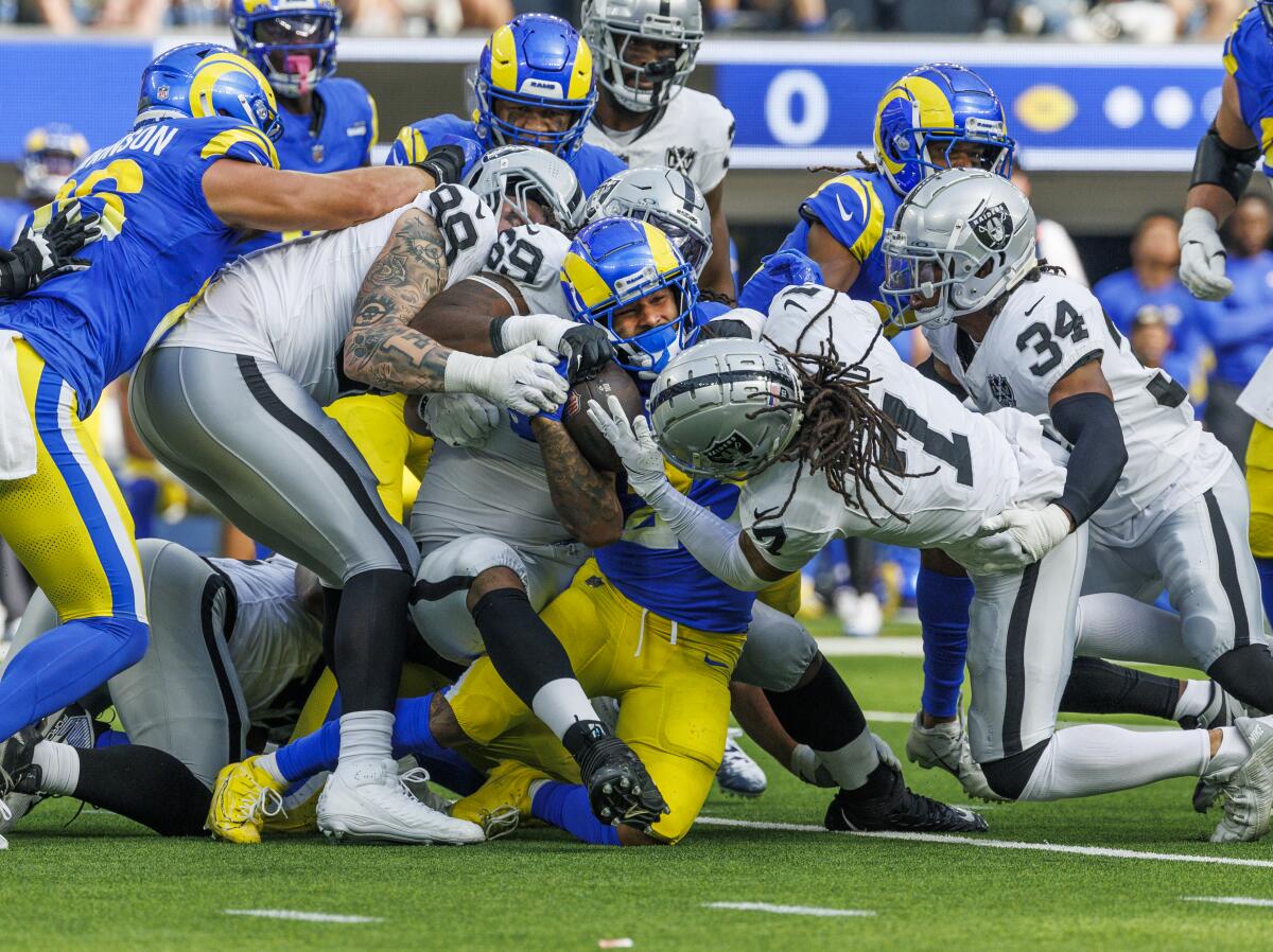 Rams running back Kyren Williams (23) is tackled by a swarm of Raiders defenders.