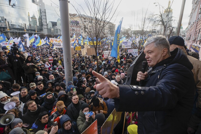 Former Ukrainian President Petro Poroshenko, right, speaks to a crowd in front of a court building prior to a court session, in Kyiv, Ukraine, Wednesday, Jan. 19, 2022. A Kyiv court is due to rule on whether to remand Poroshenko in custody pending investigation and trial on treason charges he believes are politically motivated. (AP Photo/Efrem Lukatsky)