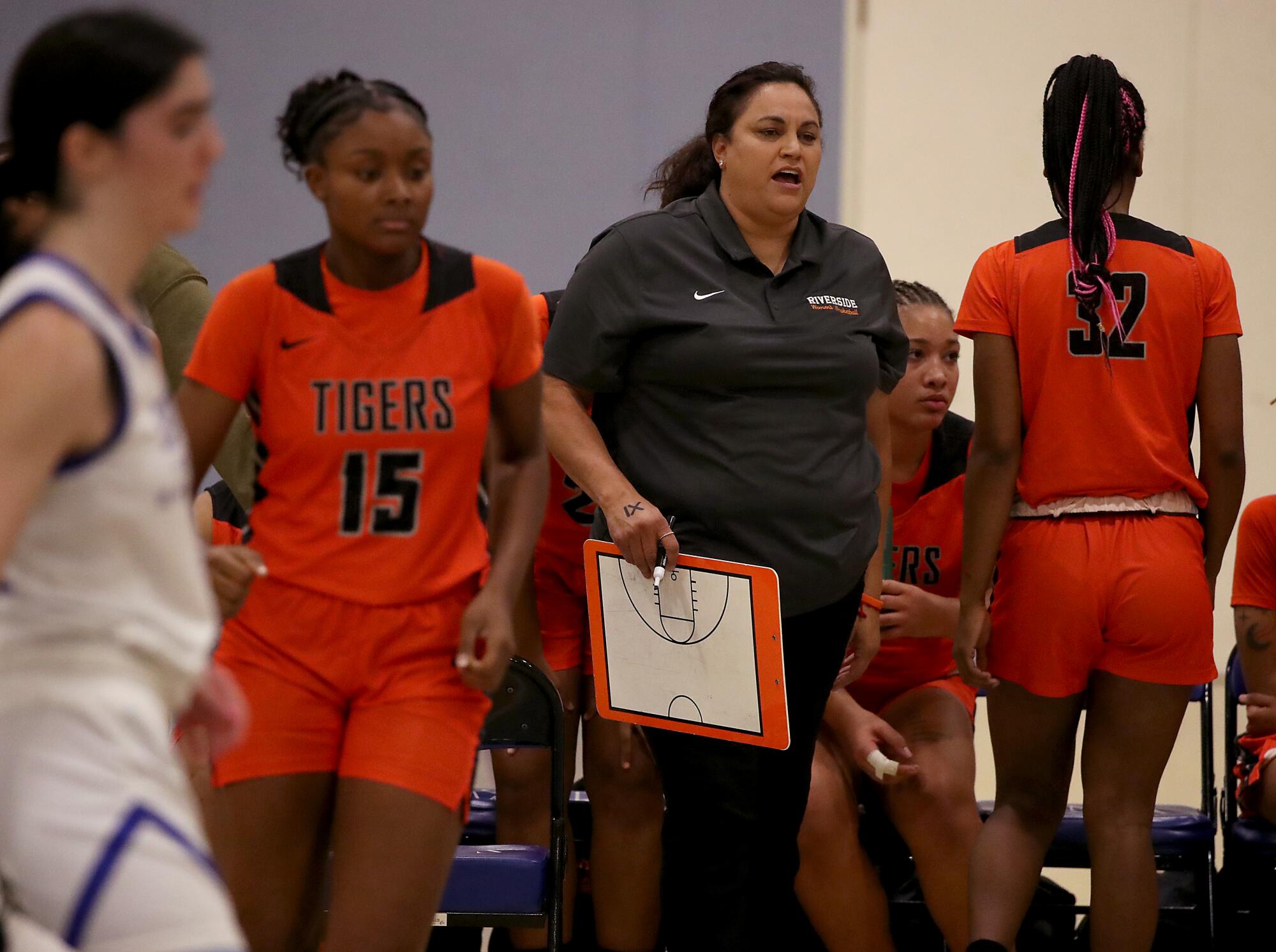 Riverside City College women's basketball coach Alicia Berber stands on the sideline during a game.