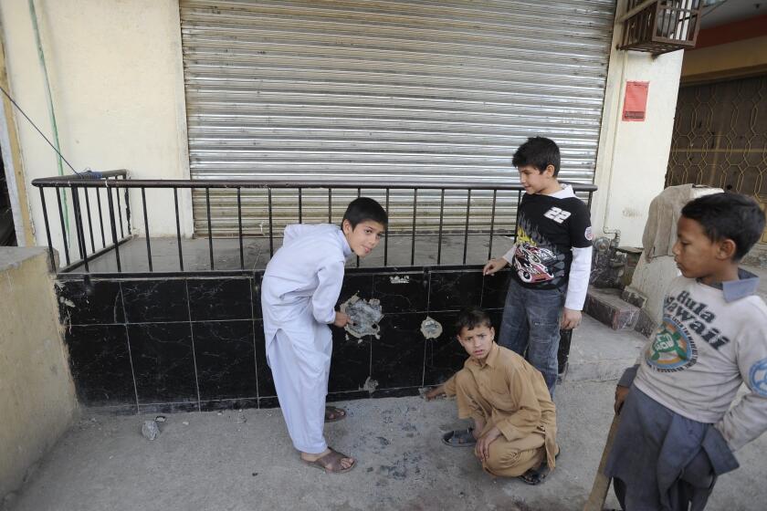 Children stand at the site where Nasiruddin Haqqani, a senior leader of the feared militant Haqqani network, was shot to death on the outskirts of Islamabad, Pakistan, on Monday.