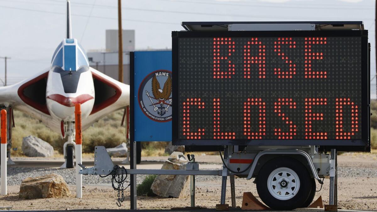 A sign announcing a base closure is posted outside the main gate to Naval Air Weapons Station China Lake on Sunday in Ridgecrest, Calif.