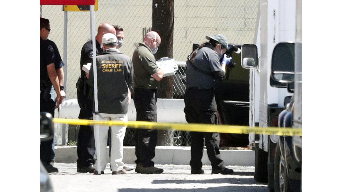 Police investigators examine the scene on South Varney Street near Linden Court in Burbank where three bodies were found inside a Jeep Patriot.