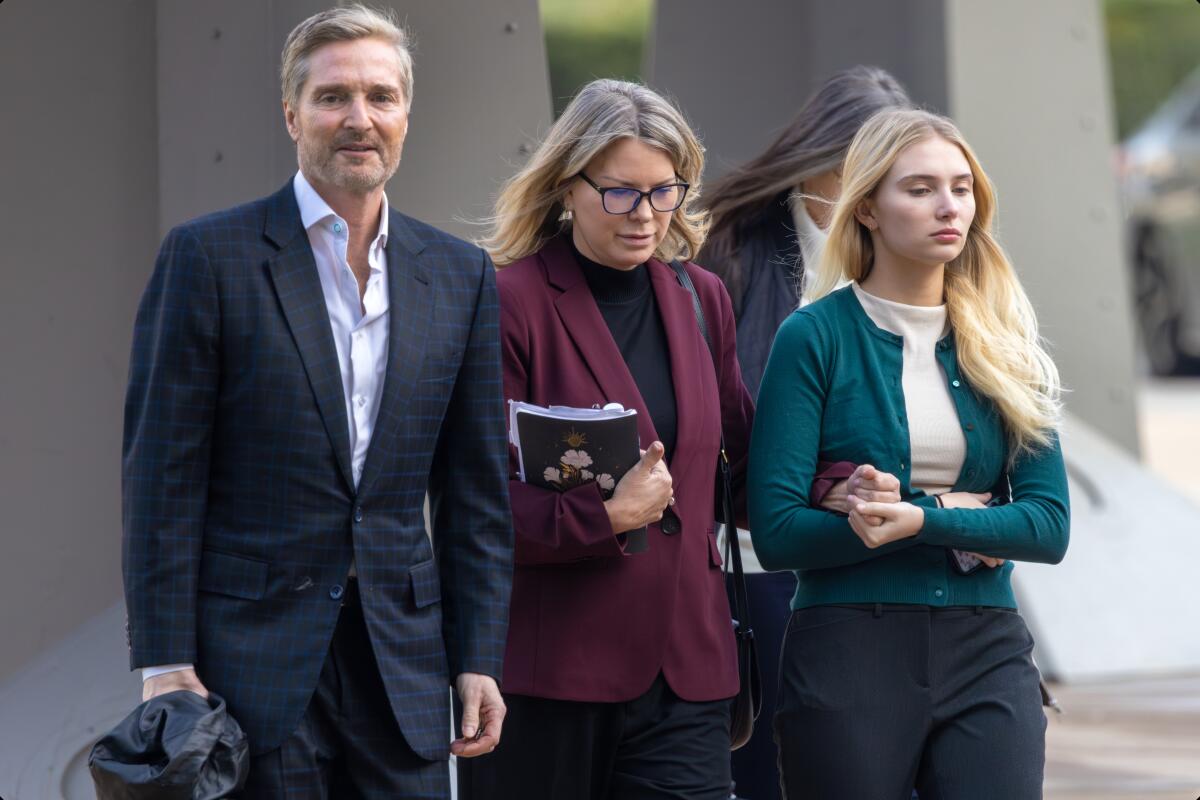 Rebecca Grossman, center, her husband, Dr. Peter Grossman, left, and her daughter head to Van Nuys Courthouse West