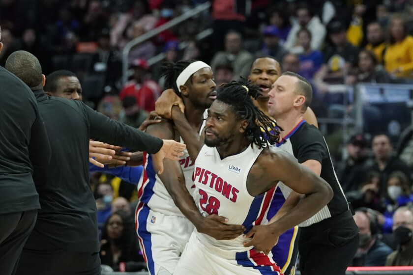El pívot de los Pistons de Detroit Isaiah Stewart es agarrado por sus compañeros y el equipo técnico luego de una falta cometida por LeBron James de los Lakers de Los Ángeles, durante la segunda mitad del partido de la NBA, el domingo 21 de noviembre de 2021, en Detroit. (AP Foto/Carlos Osorio)
