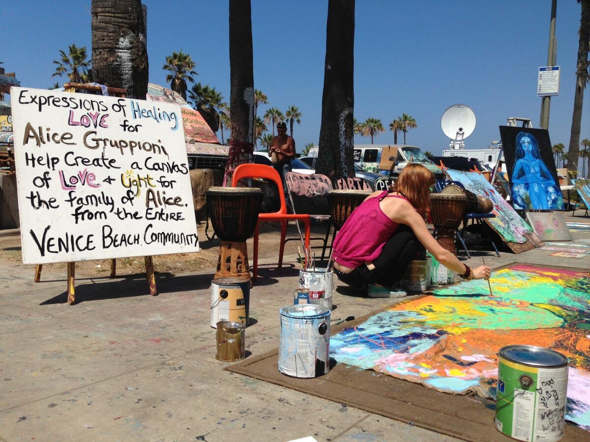 Laura Rudich, 29, of Topanga Canyon, works on a memorial for the victims from Saturday's vehicular rampage on the Venice boardwalk.