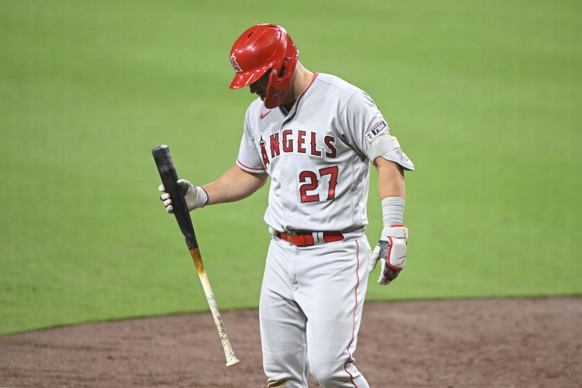 Angels star Mike Trout holds a at looks at his injured wrist after fouling off a pitch 