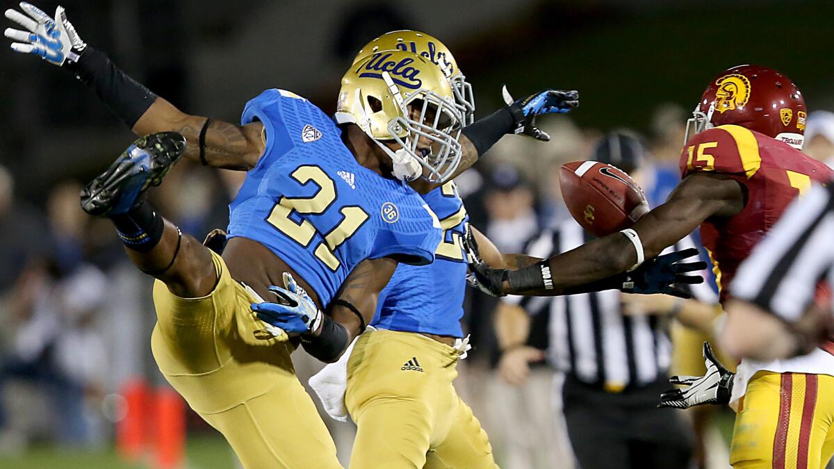UCLA defensive back Tahaan Goodman, left, assists teammate Brandon Sermons, center, in breaking up a pass intended for USC wide receiver Nelson Agholor during a game last season. Goodman likely will start Saturday against Texas.