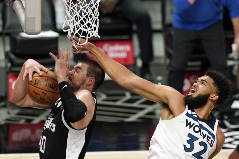 Los Angeles Clippers center Ivica Zubac, left, grabs a rebound away from Minnesota Timberwolves center Karl-Anthony Towns during the first half of an NBA basketball game Sunday, April 18, 2021, in Los Angeles. (AP Photo/Mark J. Terrill)