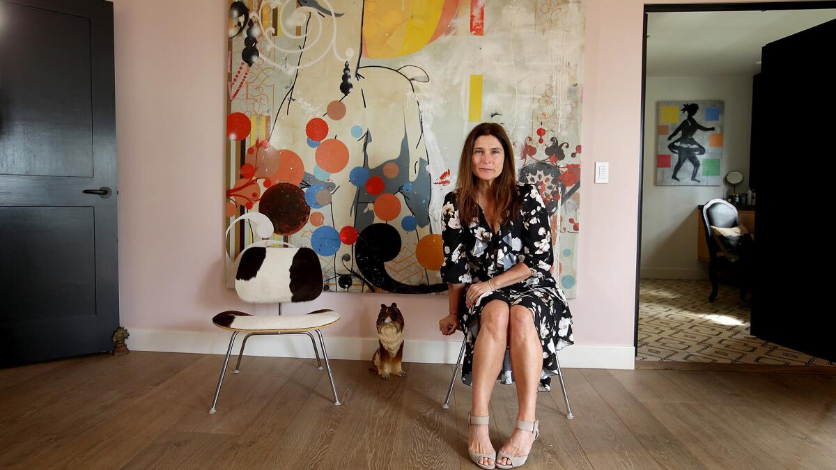 Cortney Novogratz sits in front of a colorful painting.