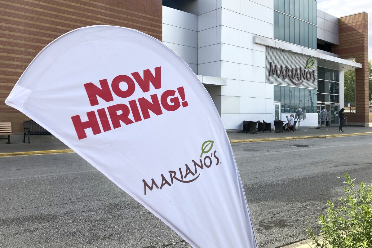A sign in the parking lot of Mariano's grocery store advertises the availability of jobs Friday, Oct. 8, 2021, in Chicago. One reason America’s employers are having trouble filling jobs was starkly illustrated in a report Tuesday, Oct. 12: Americans are quitting in droves. (AP Photo/Charles Rex Arbogast)