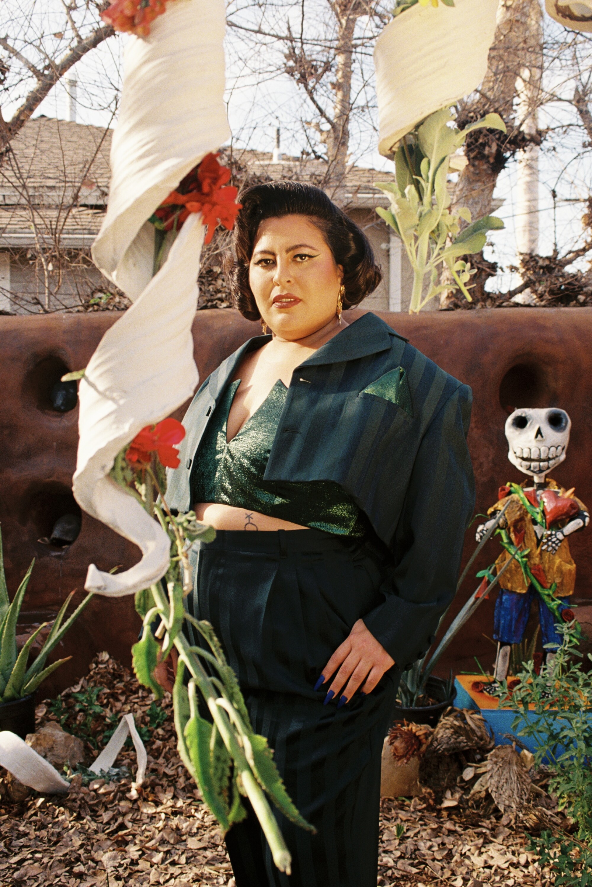 Portrait of singer San Cha in a green suit.