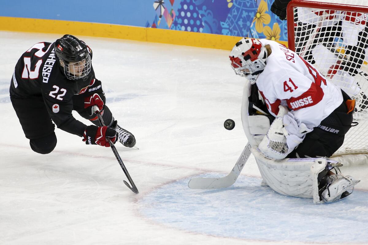 Canada's Hayley Wickenheiser tries to score past Swiss goaltender Florence Schelling during the 2014 Winter Olympics in Sochi, Russia.