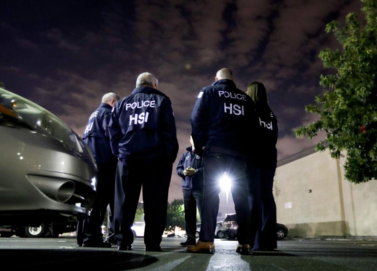 Homeland Security Investigations agents gather before serving an employment audit notice at a 7-Eleven last year in Los Angeles.