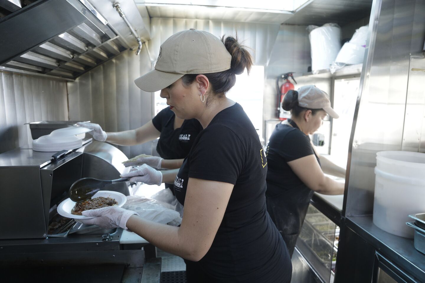 Ana Perez prepares a barbacoa vampiro at her family-owned taco truck Asadero Chikali. For the past three months, they've set up at an auto dealership lot on South Atlantic Boulevard in East Los Angeles serving breakfast, lunch and dinner.
