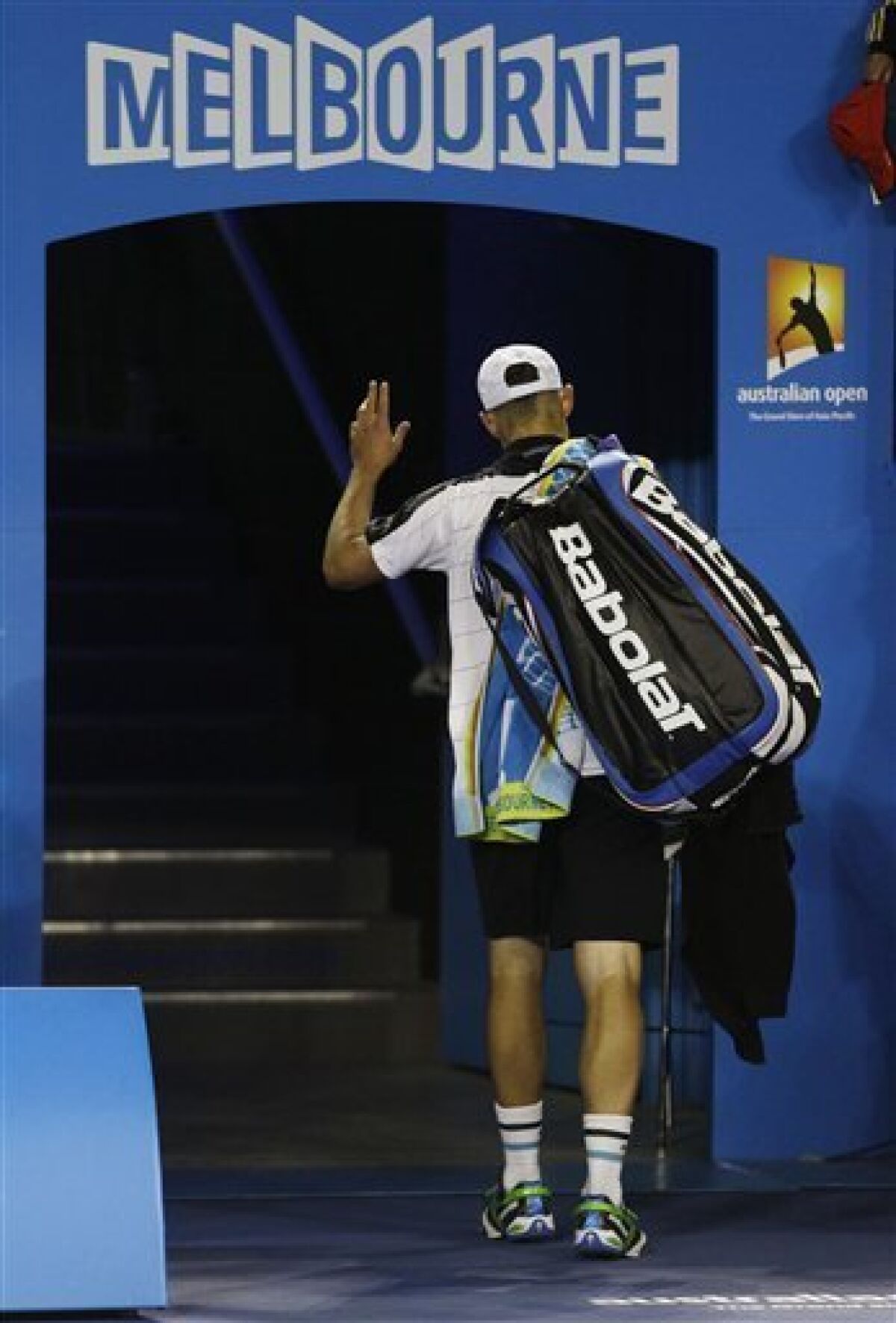 Andy Roddick of the US waves as he leaves Rod Laver Arena after retiring injured from his second round match against Australia's Lleyton Hewitt at the Australian Open tennis championship, in Melbourne, Australia, Thursday, Jan. 19, 2012. (AP Photo/Rick Rycroft)