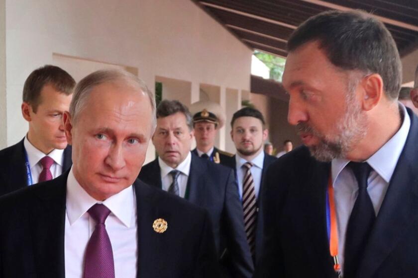 File-This Nov. 10, 2017, file photo shows Russia's President Vladimir Putin, left, and Russian metals magnate Oleg Deripaska, right, walking to attend the APEC Business Advisory Council dialogue in Danang, Vietnam. The United States punished dozens of Russian oligarchs and government officials on Friday, April 6, 2018, with sanctions that took direct aim at President Putin's inner circle, as President Donald Trump's administration tried to show he's not afraid to take tough action against Moscow. Seven Russian tycoons, including aluminum magnate Deripaska, were targeted, along with 17 officials and a dozen Russian companies, the Treasury Department said. (Mikhail Klimentyev, Sputnik, Kremlin Pool Photo via AP, File)