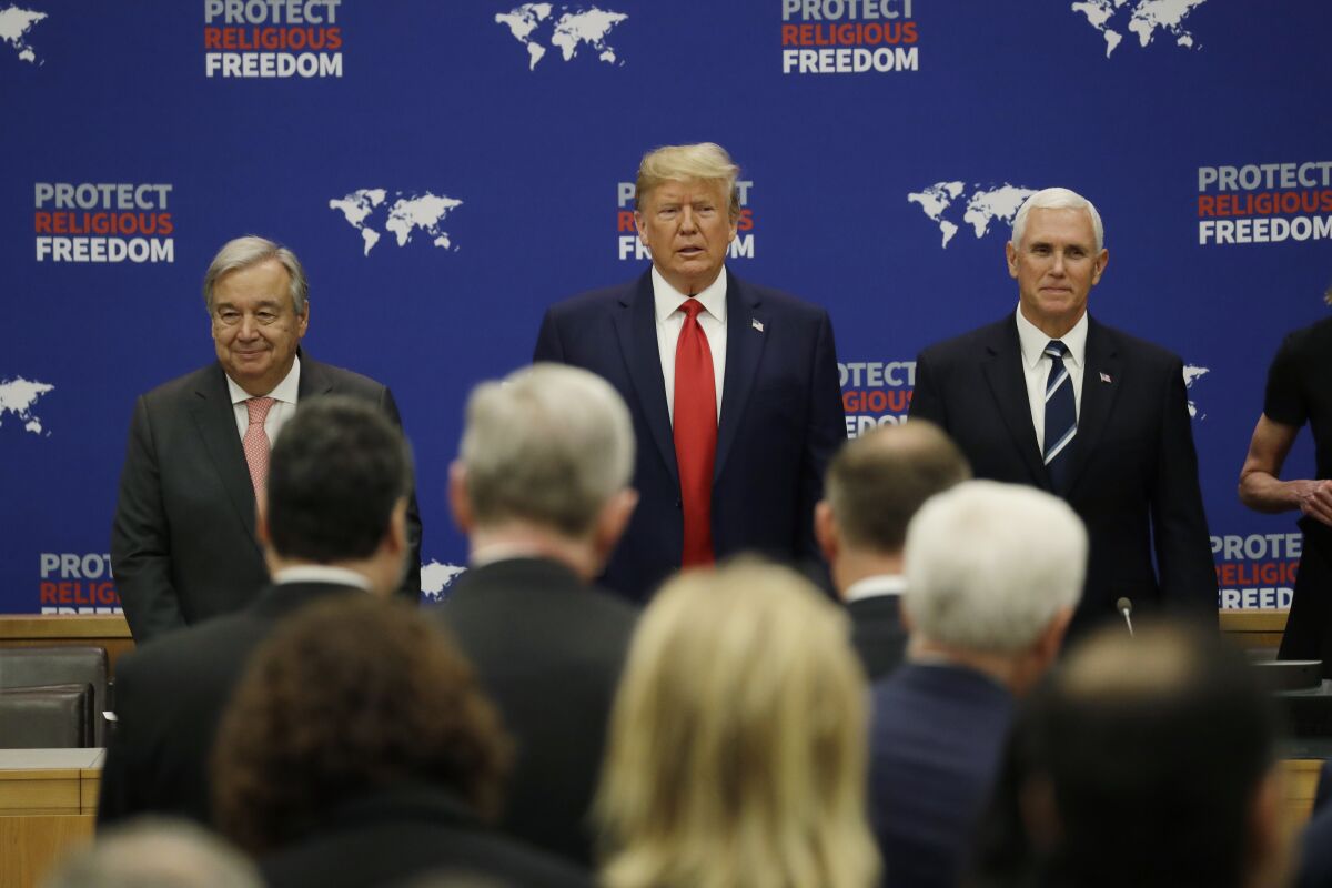 President Trump arrives at an event on religious freedom during the U.N. General Assembly on Monday. He is flanked by U.N. Secretary-General Antonio Guterres, left, and Vice President Mike Pence.