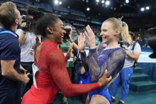 Simone Biles, left, celebrates after winning the gold medal along with bronze medalist.