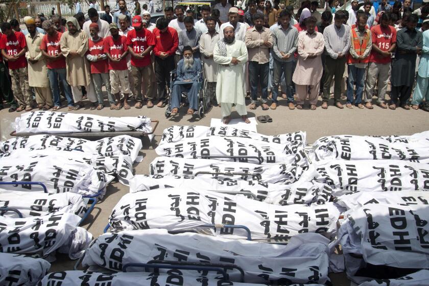 FILE - In this Friday, June 26, 2015 file photo, mourners attend a funeral for unclaimed people who died of extreme weather, in Karachi, Pakistan, after a devastating heat wave that struck southern Pakistan the previous weekend, with over 800 confirmed deaths according to a senior health official. A study published in Nature Climate Change on Monday, May 31, 2021, has calculated that more than one-third of global heat deaths can directly be attributed to human-caused climate change. (AP Photo/Shakil Adil)