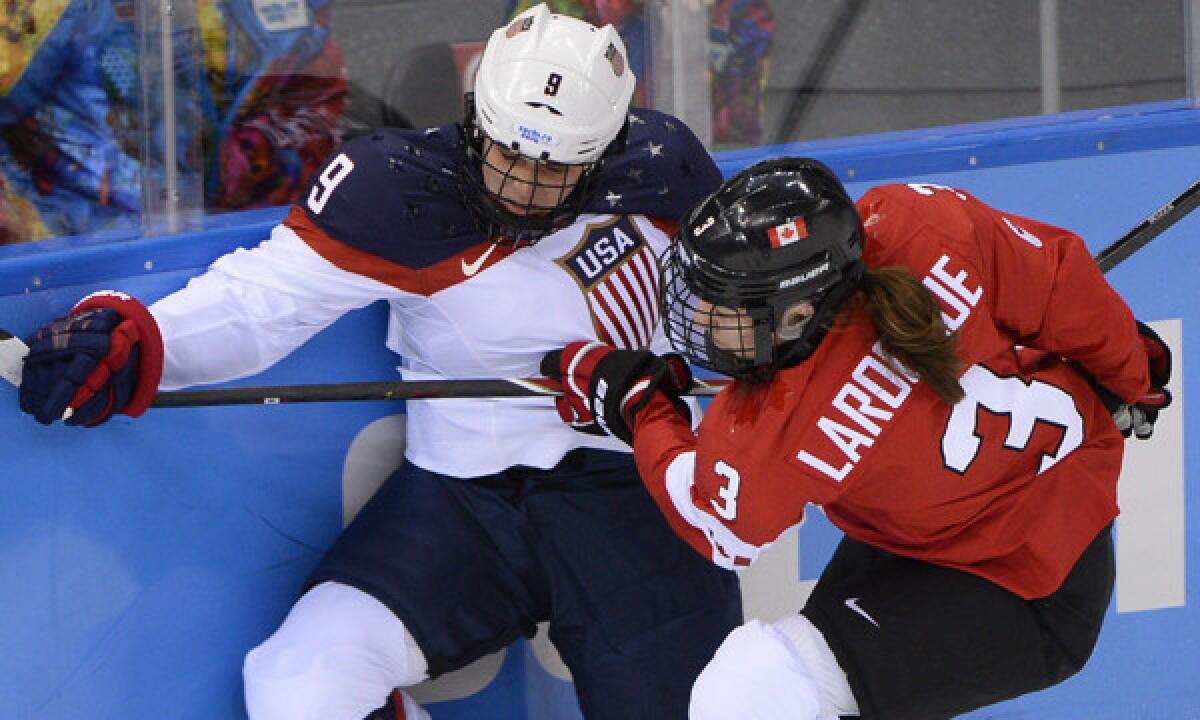 Canada defenseman Jodelyne Larocque, right, checks U.S. defenseman Megan Bozek during Team USA's 3-2 loss Wednesday at the Sochi Winter Olympic Games.